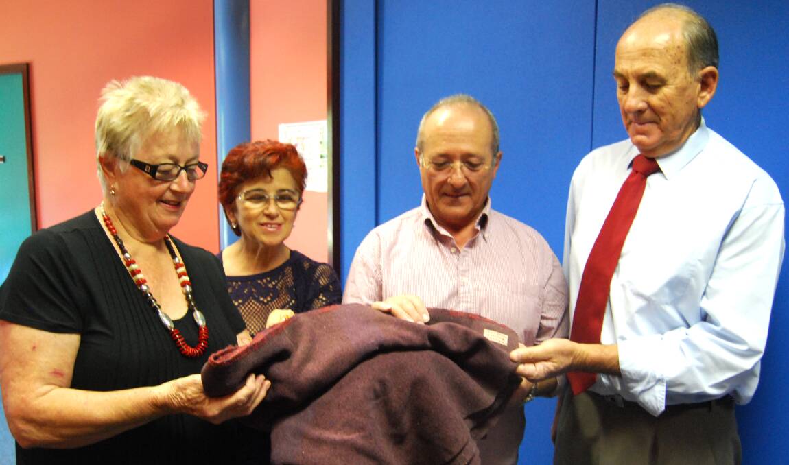 PIECE OF HISTORY: Cowra-Italy Friendship Association president Maria Bell, Maria and Luciano Giannotti, and Mayor Bill West with Ramiro Giannotti's POW blanket.